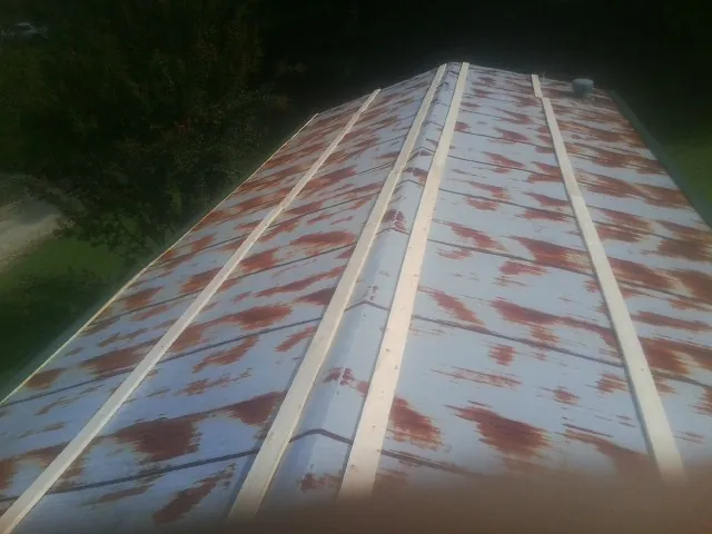Rusted metal roof panels with new wood purlins before replacement — Storm Damage Roof Repair in Arvonia by Roofing Brothers
