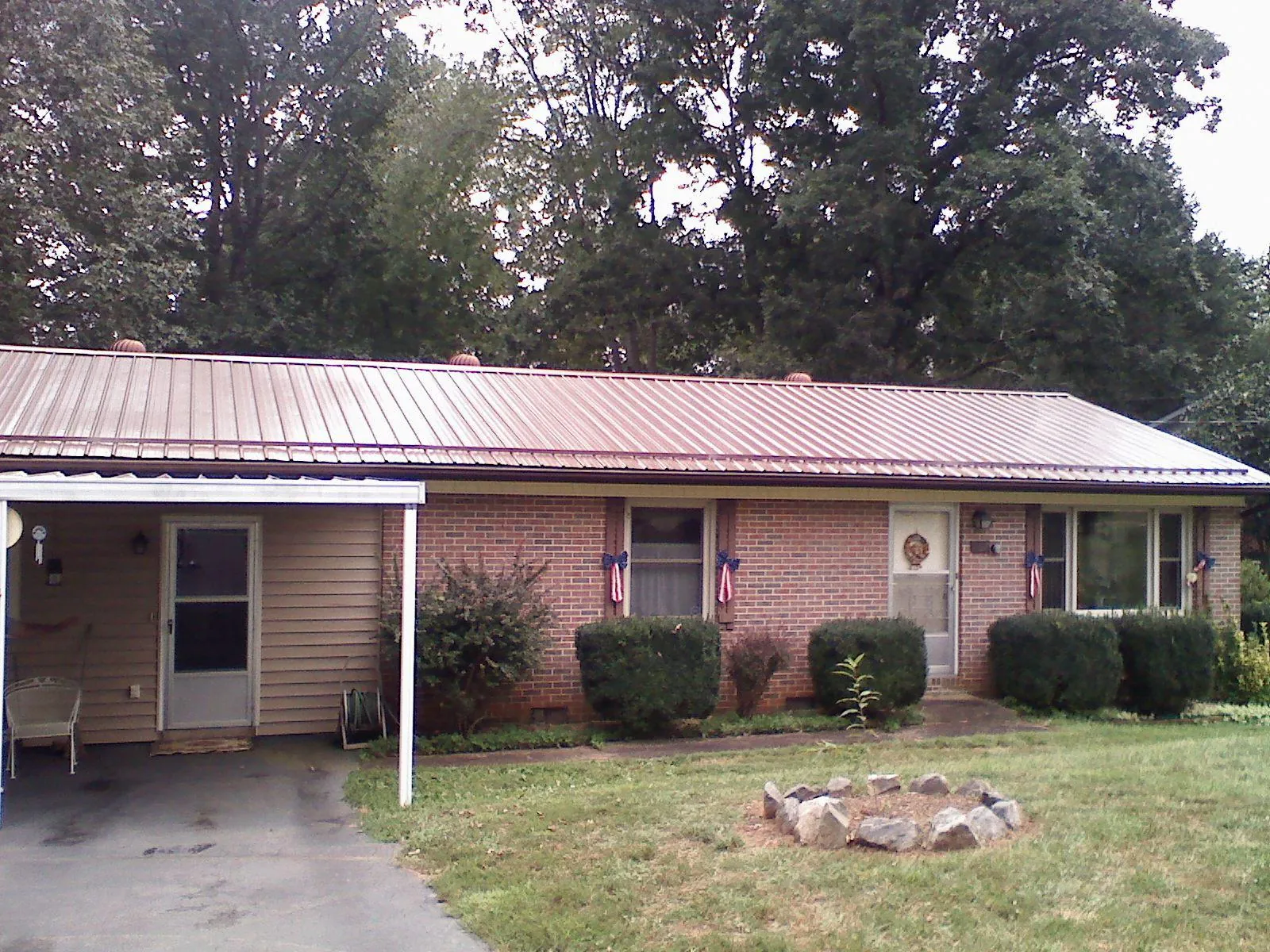 Bronze metal roof and carport on a brick ranch home — Roof Repair work by our crew in Arvonia